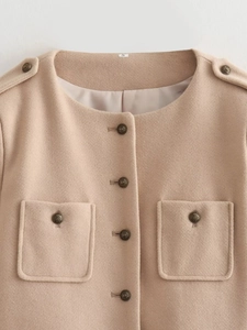 Detail of wool-textured short jacket with vintage metal buttons and pocket accents