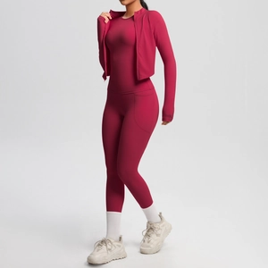 Close-up of deep red yoga set featuring high-waisted leggings and zip-up jacket details