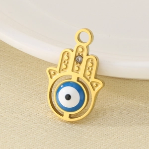 Close-up of a gold Hamsa hand pendant with a blue evil eye bead and rhinestones