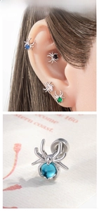 Macro shot of spider shaped cartilage earrings with colorful gemstone inlays on models