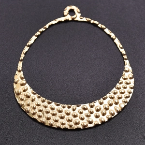 Detailed close-up of golden crescent pendant featuring unique hammered texture and top ring