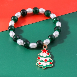 Detailed view of beaded Christmas bracelet with green glass beads and enamel tree charm