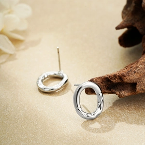 Detail view of silver earrings with balloon-style crinkle texture and oval design
