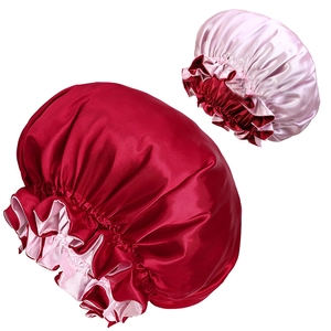 Dettaglio di cuffie da notte in raso bordeaux e rosa con elastico e texture liscia