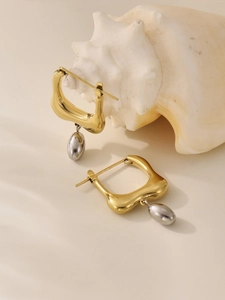 Artistic detail of geometric stainless steel earrings with gold square and silver oval drop