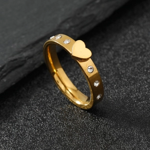 Polished golden heart ring with sparkling crystals on stainless steel band, 45-degree view
