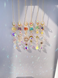 Detail of crystal suncatchers casting rainbow light on a wall with golden tree of life symbols