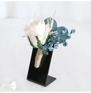 Detailed view of white silk rose boutonniere with blue berries and jute twine wrap