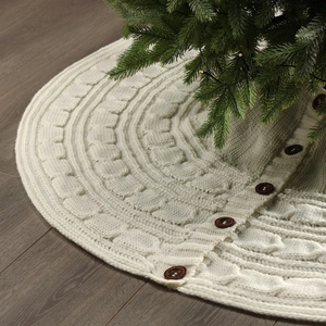 Detail of cream cable knit Christmas tree skirt with decorative brown wooden buttons