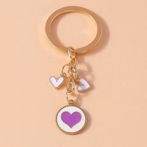 Golden heart keychain featuring white enamel charms and a purple heart round pendant