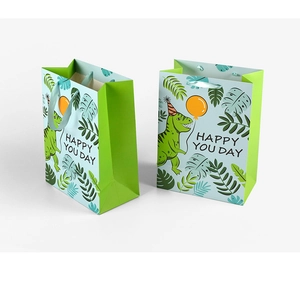 Detail of green cartoon dinosaur gift bags with Happy You Day text and party balloons
