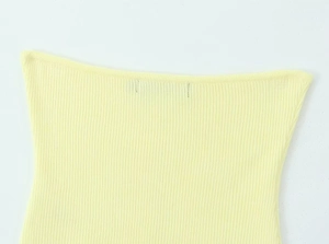 Primer plano detallado de la textura de punto acanalado amarillo claro del conjunto de falda
