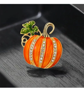 Macro detail of Halloween pumpkin brooch with orange enamel and sparkling white rhinestones