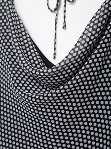 Detail of polka dot dress featuring halter neck tie and cowl neckline texture