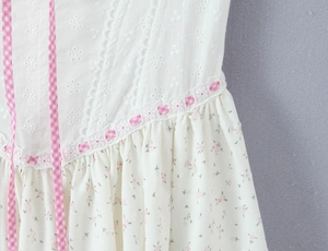 Détail de la broderie florale et de la dentelle ajourée sur une robe en coton blanc
