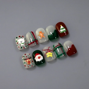5D Christmas press-on nails with 3D Santa, reindeer, and gingerbread designs on gray background