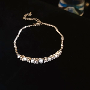 Detail of gold-plated bracelet with white pearls and sparkling cubic zirconia stones