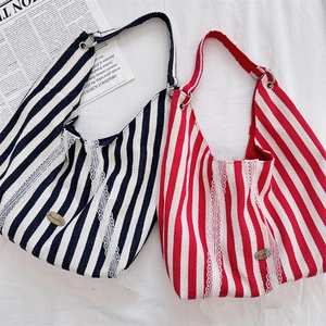 Gros plan sur les sacs cabas en toile rayée avec dentelle délicate et boucles métalliques