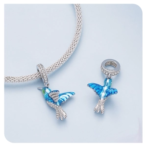 Macro detail of 925 sterling silver hummingbird charm with blue enamel and zircon stones