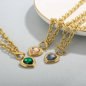 Macro shot of 18k gold heart pendant necklaces with toggle clasp and colorful crystals