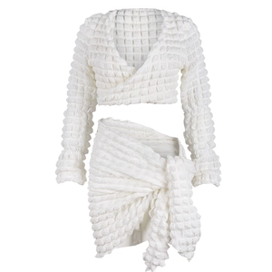 Macro view of white popcorn texture fabric on this long sleeve crop top and skirt set