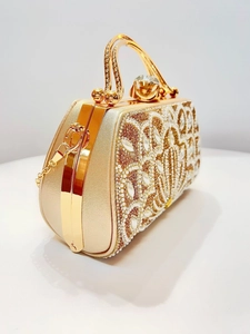 Close-up of champagne gold evening bag with pearls, rhinestones and floral beadwork embroidery