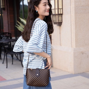 Women's dark brown crossbody bucket bag with geometric print shown on a model