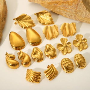 Detail shot of golden geometric stud earrings with leaf and floral motifs on stone