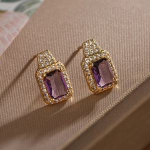 Macro detail of gold plated square purple zircon earrings with halo diamond setting