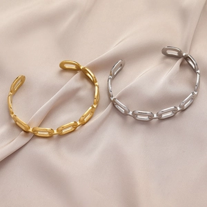 Detail view of gold and silver stainless steel chain link bracelets on pink silk