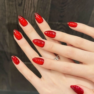 Deep red cat-eye press-on nails with ruby shimmer and magnetic glitter on hands