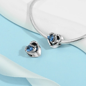 Macro detail of S925 silver heart charm with blue gem and Always my mother engraving