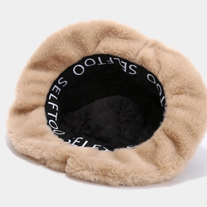 Vue détaillée du chapeau bob en peluche beige avec doublure matelassée et ruban à logo stylé