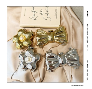 Detail of mini acrylic pearl flower and bow bags with gold and silver metal chains