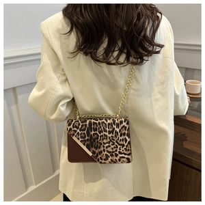 Detail of leopard print bag with gold chain strap and brown faux leather trim
