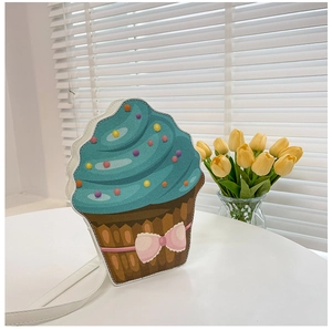 Detail of creative cupcake shoulder bag with blue cream topping and pink bow decoration