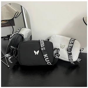 Detail of black and white nylon crossbody bags with silver butterfly and lettered straps