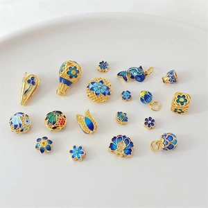 Detail of 18K gold and blue enamel flower and fish charms for DIY jewelry making