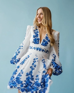 Detailed view of bohemian white dress with blue floral embroidery and puff sleeves