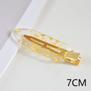 Detail shot of a 7cm acetate hair clip with gold foil inlay and a metallic base