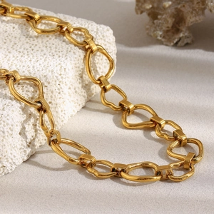 Detailed view of 18K gold-plated chain necklace on white coral stone background