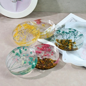 Detailed close-up of DIY resin coasters with dried flowers and tiger eye stone inclusions