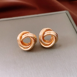 Vue macro de boucles d'oreilles nœud doré poli avec un design élégant de corde torsadée