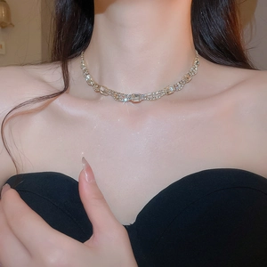 Detail of silver choker necklace featuring a sparkling square-cut pendant on model