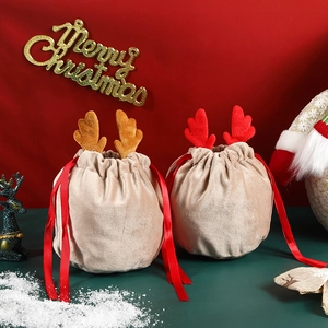 Velvet Christmas reindeer gift bags with 3D antlers and red ribbons in a festive setting