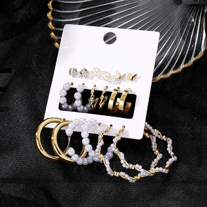 Detailed set of butterfly and pearl earrings in gold finish on white card