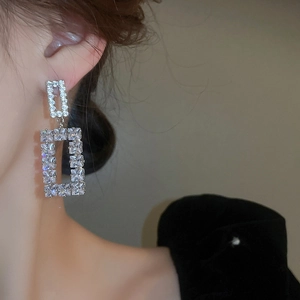 Detail shot of silver square hollow earrings with sparkling cubic zirconia on model