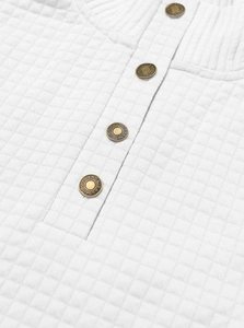 Detail of white quilted jacket fabric with vintage bronze buttons and grid texture