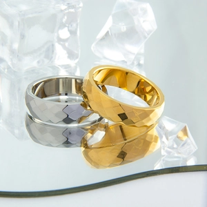 Makro-Detail von 6mm facettierten Gold- und Silberringen aus Titanstahl auf Spiegel