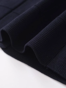 Macro shot of dark blue ribbed knit fabric showing fine texture and weave detail